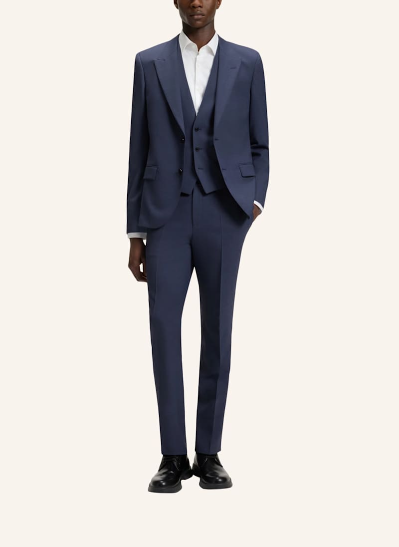 Mann trägt einen blauen Komplettanzug, bestehend aus Sakko, Weste und Anzughose