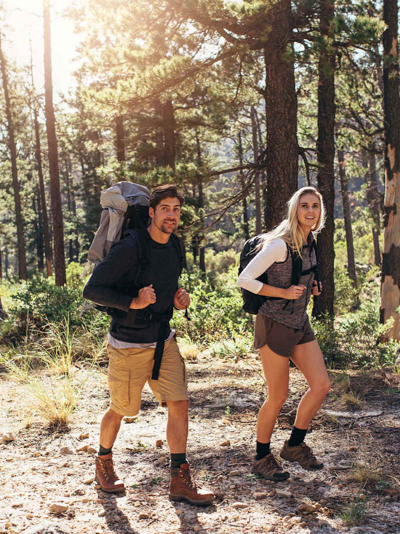 Ein Paar wandert im Wald mit Wanderrucksäcken 