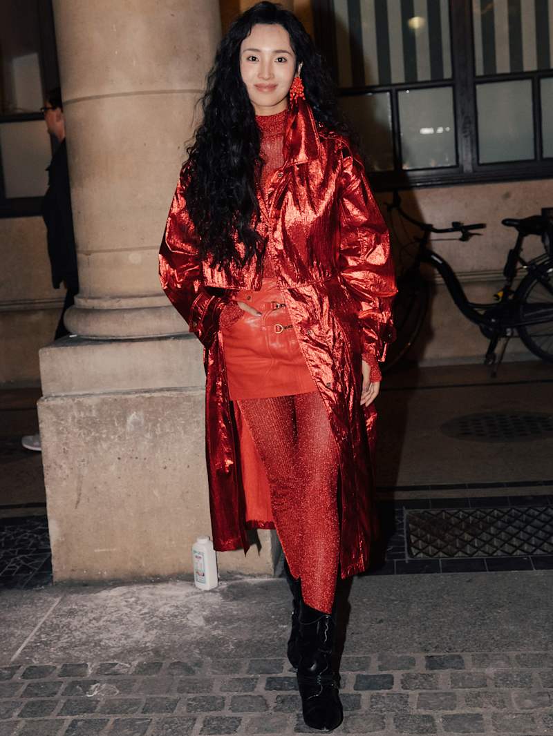 Frau trägt ein monochromen Look in der Farbe Rot, bestehend aus Mantel, Shirt, Rock und passender Strumpfhose