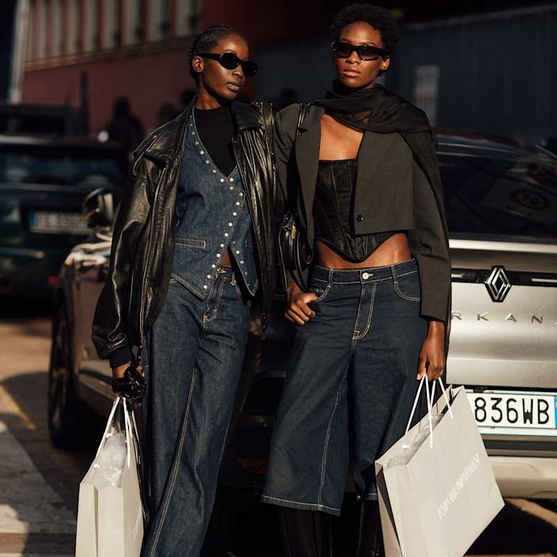 Zwei Frauen stehen auf der Straße und tragen angesagte Jeans-Outfits