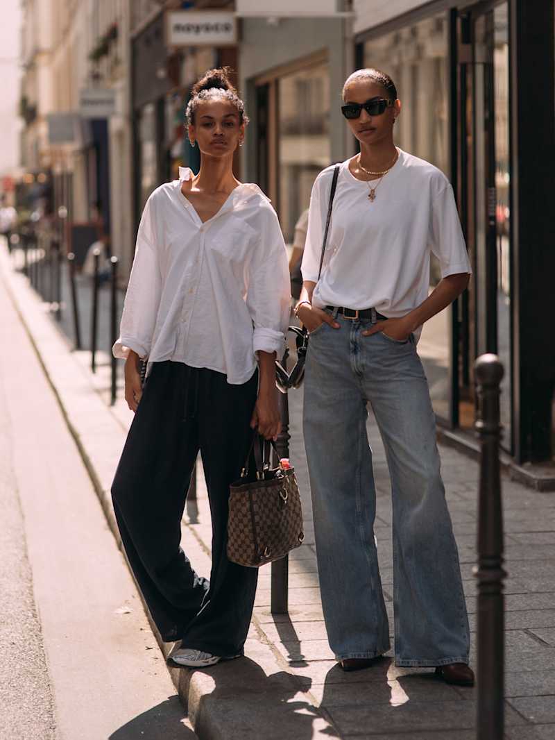 Zwei Frauen tragen Blue Jeans zu einem weißen T-Shirts und Bluse