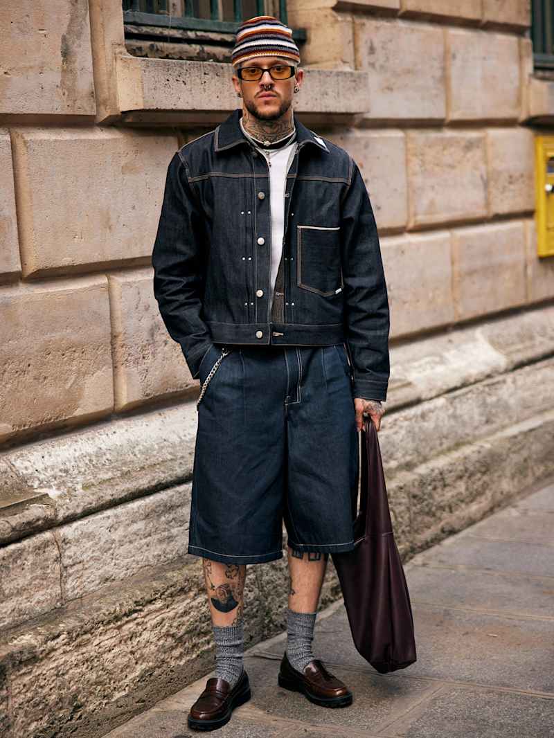 Mann trägt einen Zweiteiler aus Indigo Denim, bestehend aus Jeansjacke und Shorts