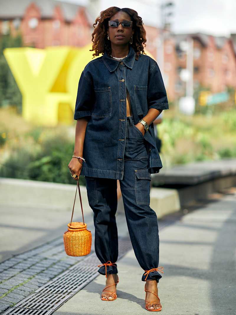 Frau trägt ein Set aus Jeansbluse und Jeanshose in einem dunkelblauen Denim