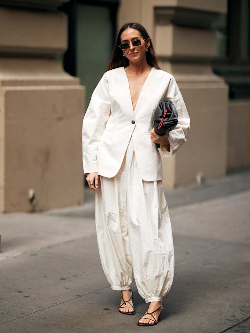 Frau trägt eine weiße Hose zu einem weißen Blazer