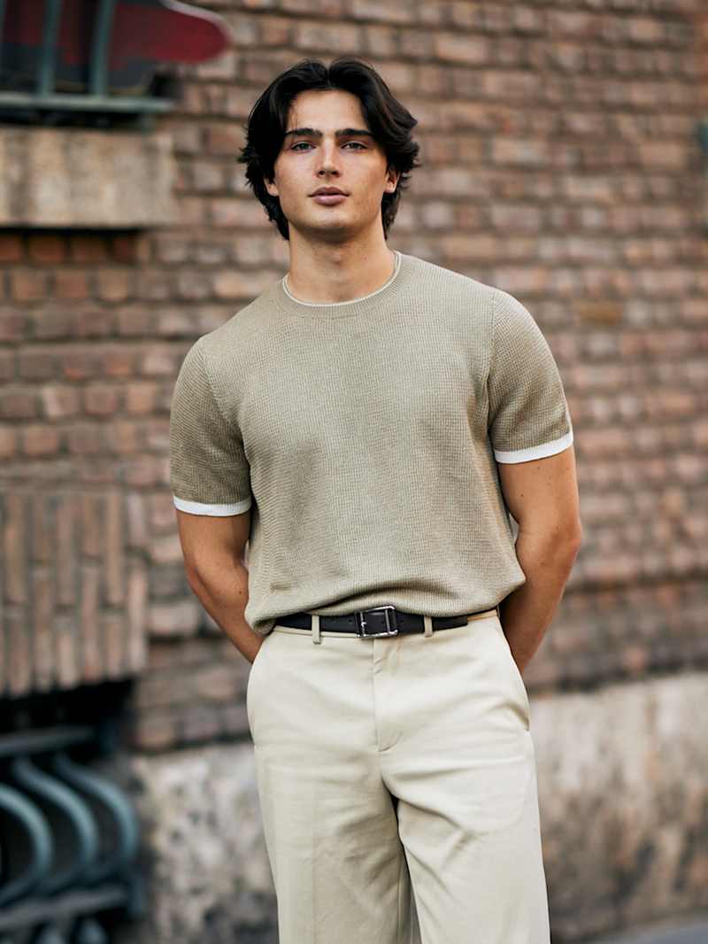 Brünetter Mann trägt seine mittellangen Haare im Mittelscheitel