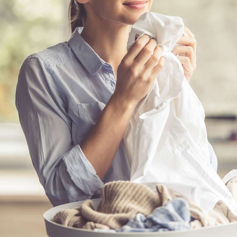 Frau sortiert und faltet frisch gewaschene Wäsche