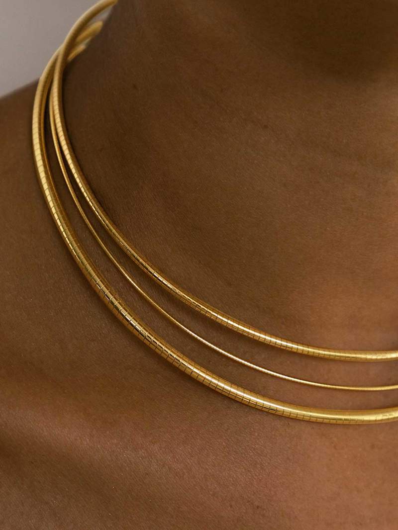 Frau trägt ein angesagtes Ketten-Layering mit dem Schmucktrend Key-Piece Choker