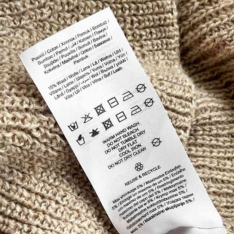 Waschsymbole auf dem Etikett eines Pullovers