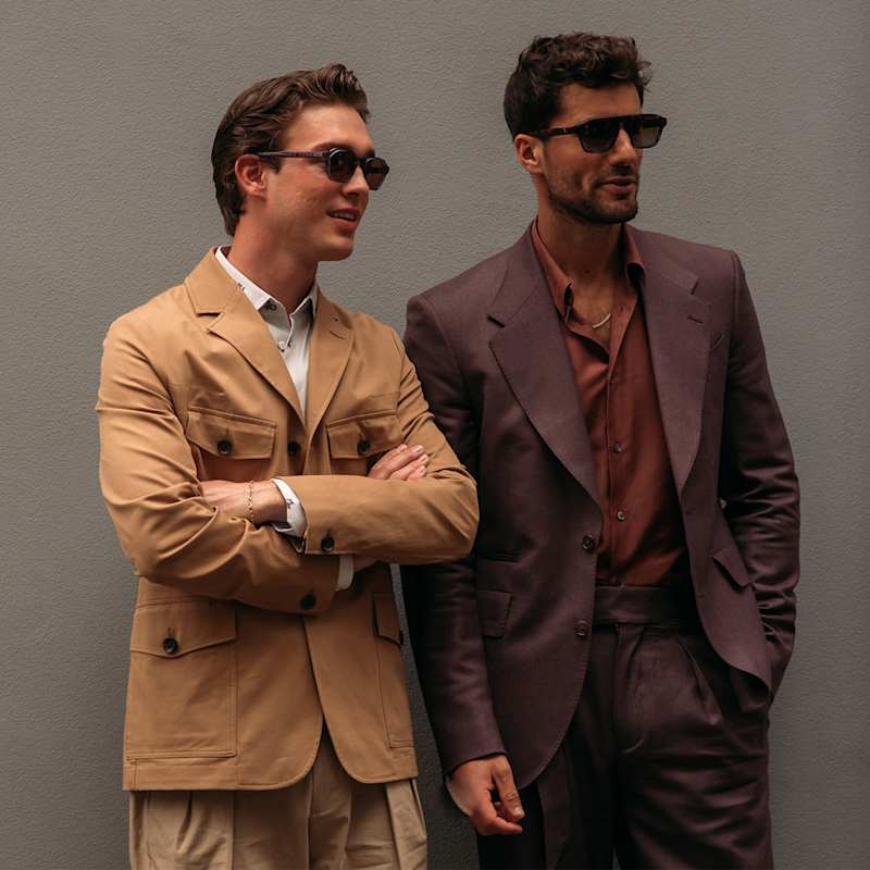 Zwei Männer tragen mit Anzug und Sonnenbrille aktuelle Modetrends für Herren