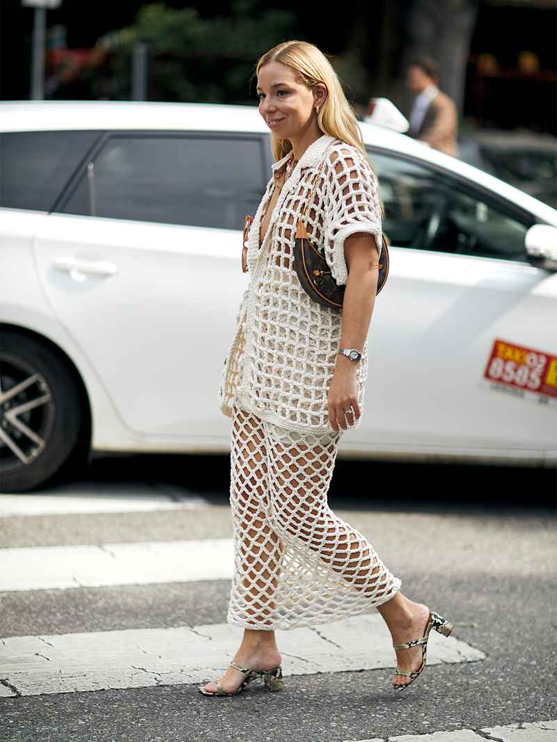 Frau im weißen Netz-Outfit trägt kleine Leder-Handtasche