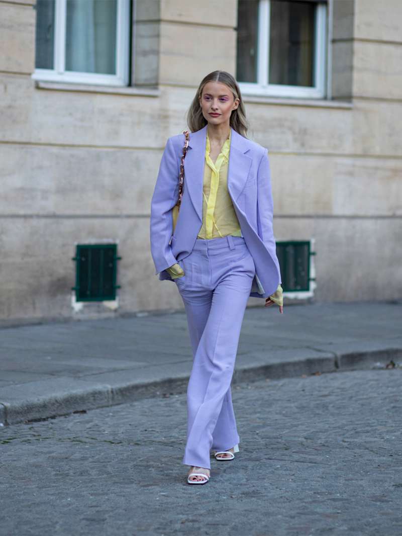 Große Frau in gelber Bluse und lila Outfit