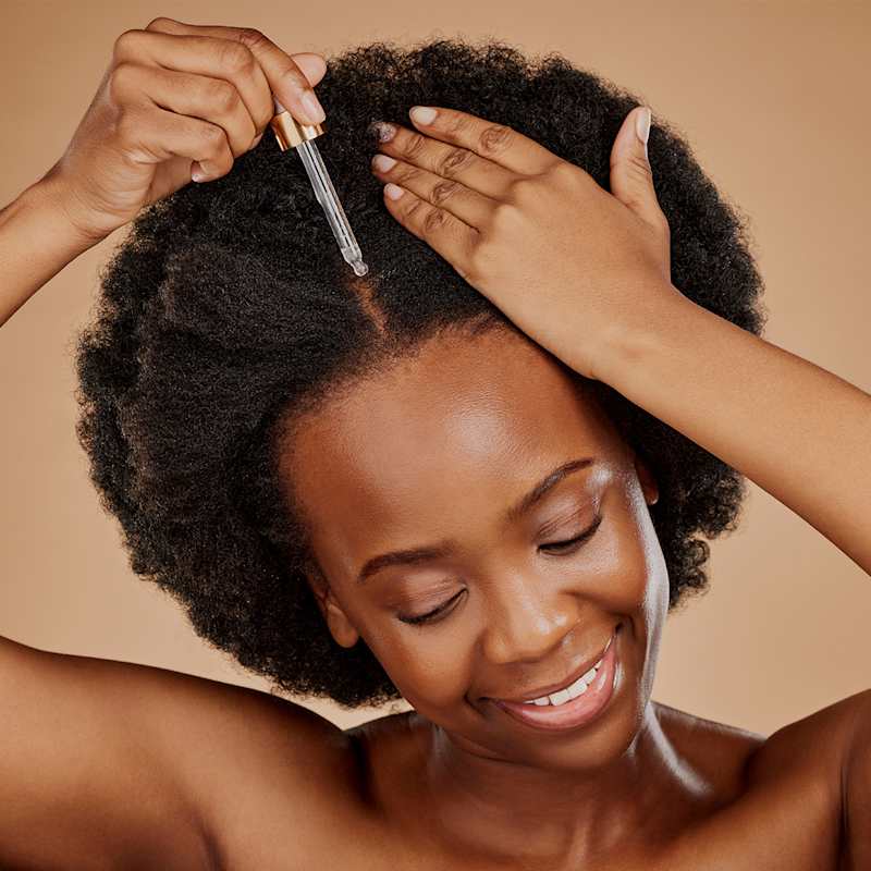 Brünette Frau pflegt ihre Kopfhaut und Haare mit Rizinusöl