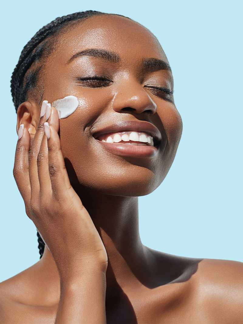 Brünette Frau trägt Pflege mit Sheabutter auf ihr Gesicht auf