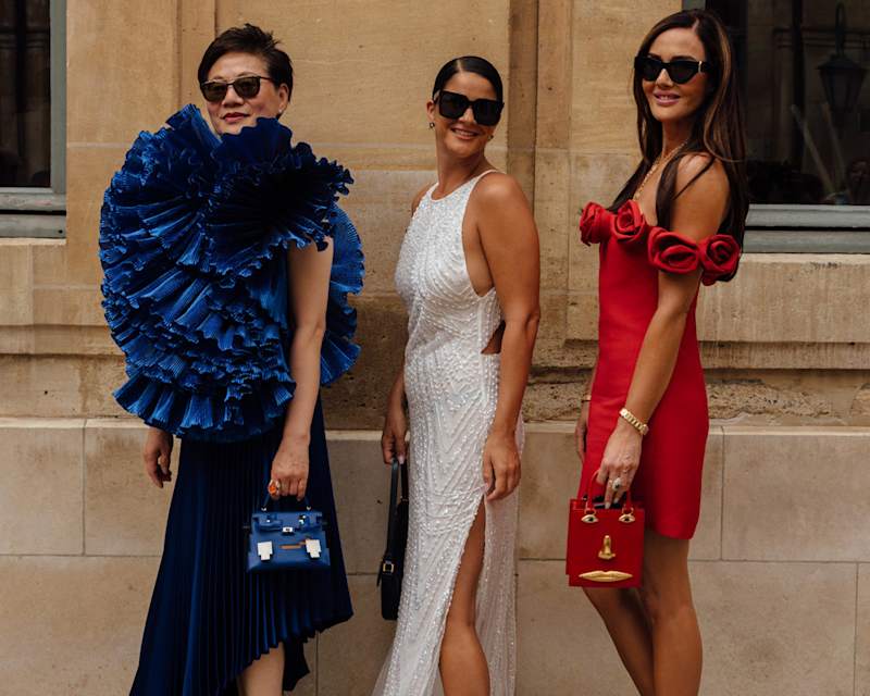 Drei Frauen tragen festliche Kleider, jeweils in den Farben Blau, Weiß und Rot