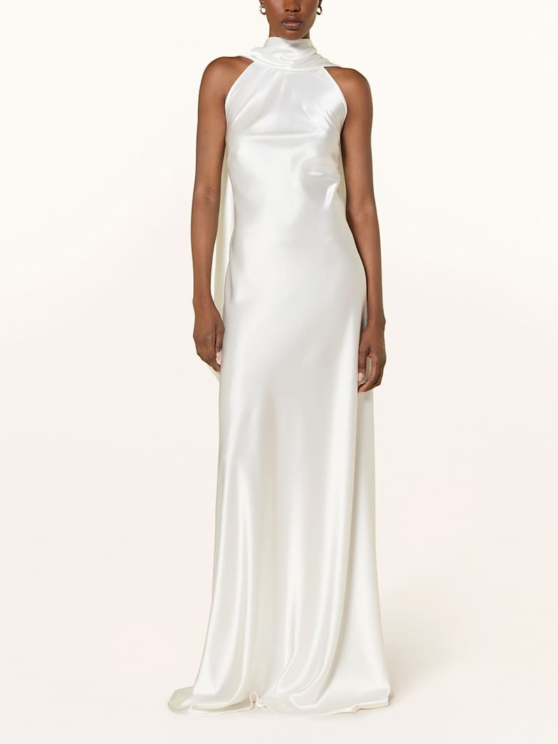 Frau trägt ein bodenlanges, weißes Satinkleid mit Neckholder