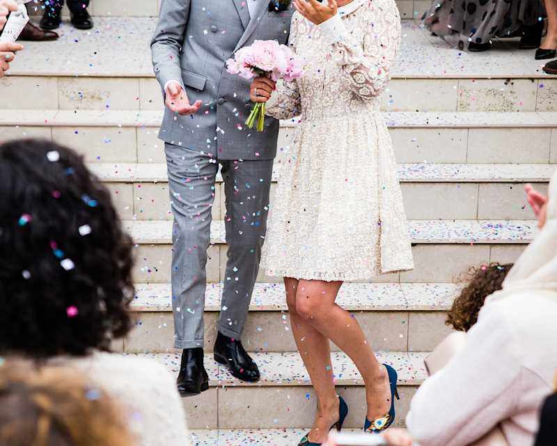 Mann und Frau stehen auf einer Treppe in Hochzeitskleidung