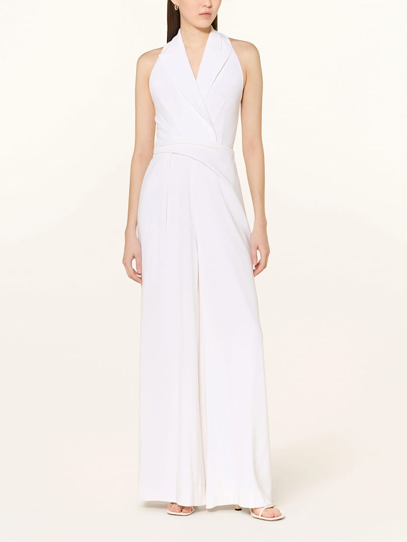 Frau trägt einen weißen Jumpsuit