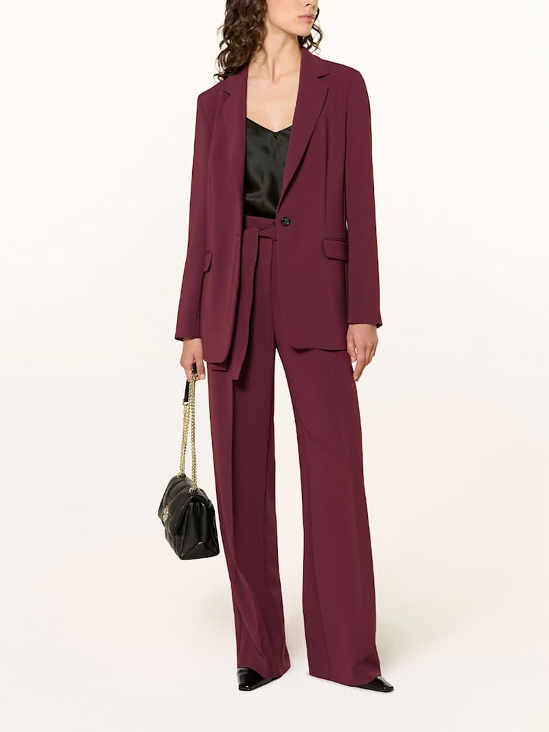 Frau trägt einen dunkelroten Zweiteiler aus Blazer und Hose