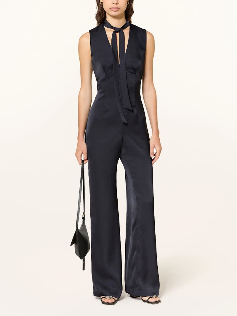 Frau trägt einen dunkelblauen Jumpsuit aus Satin