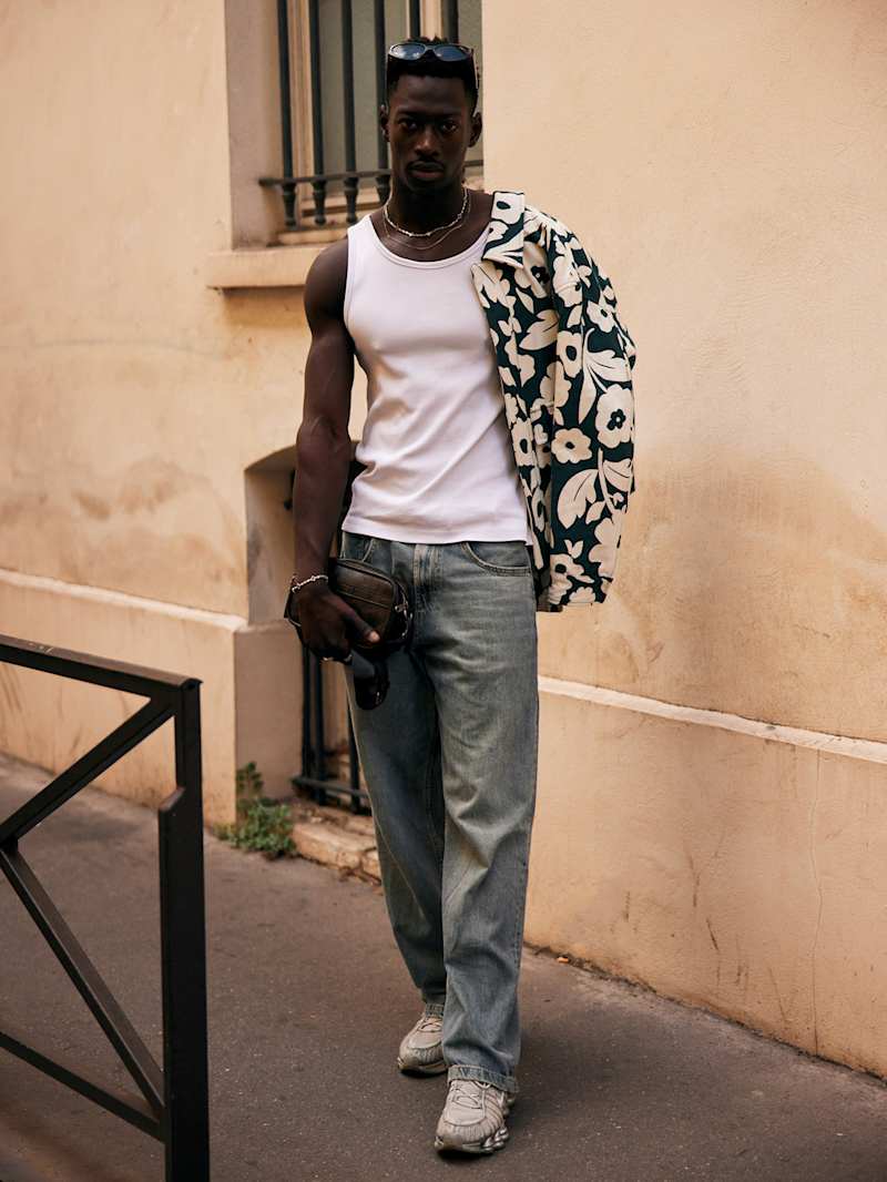 Mann trägt eine Jeans zu weißem Tank-Top und Resort-Hemd