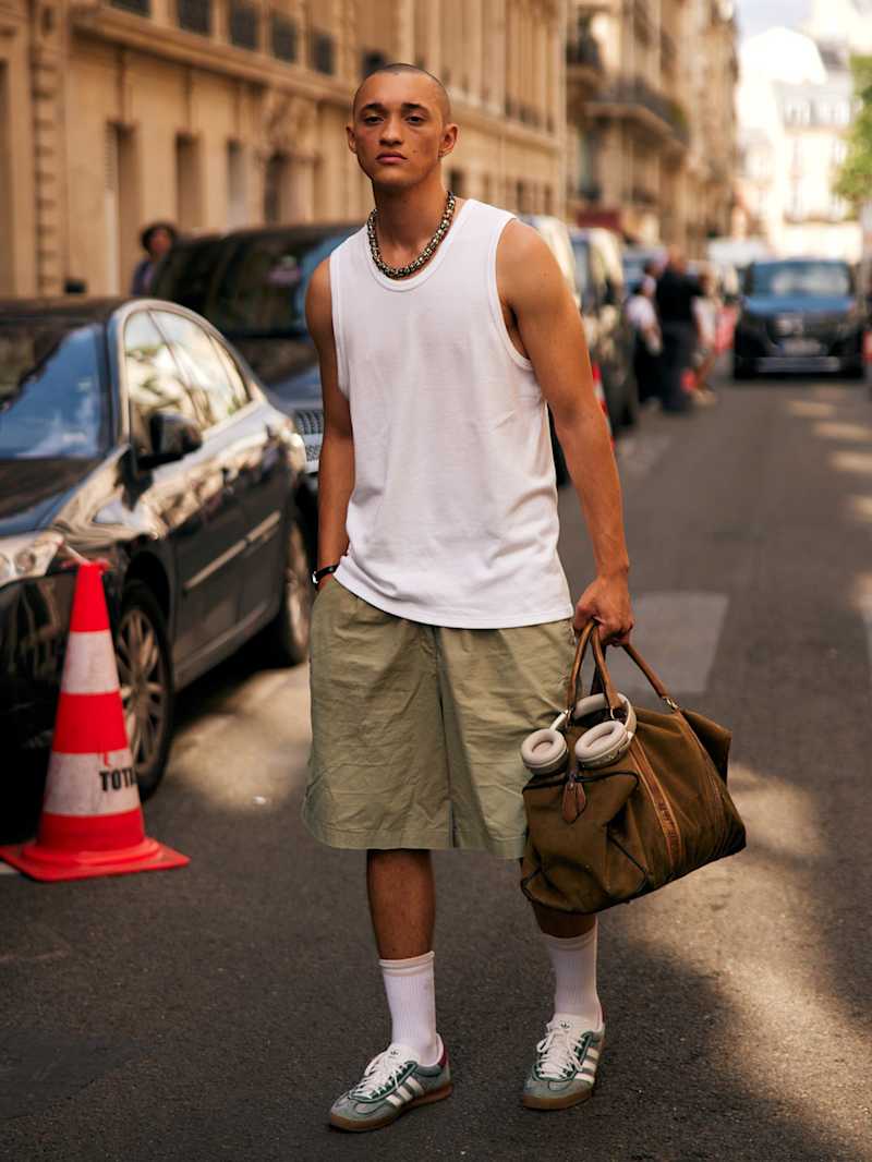 Mann trägt ein weißes Top zu Shorts und Retro-Sneaker