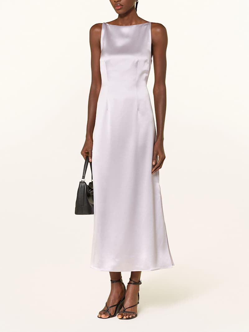 Frau trägt ein knöchellanges Kleid aus Satin in Flieder