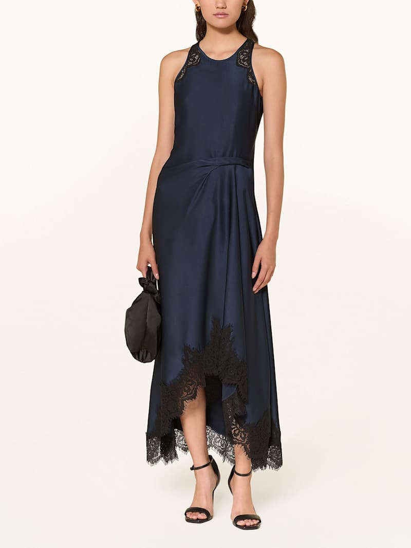 Frau trägt ein blauen Satinkleid mit schwarzer Spitze