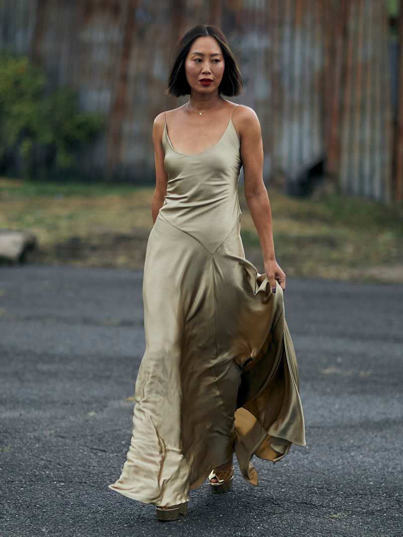 Frau trägt ein langes, grünes Satinkleid