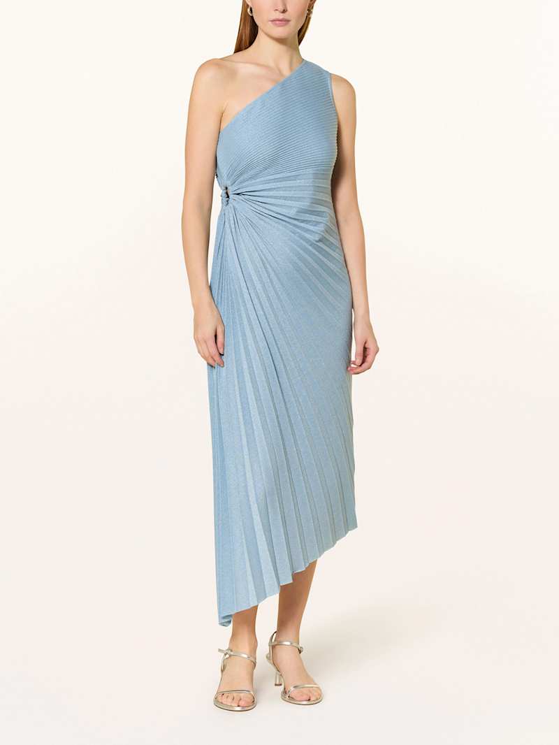 Frau trägt ein knöchellanges One-Shoulder Kleid in der Farbe Blau