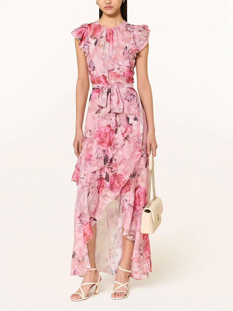 Frau trägt Kleid mit leicht ausgestelltem Rockteil und einem Allover Blüten-Muster in Crêpe-Qualität