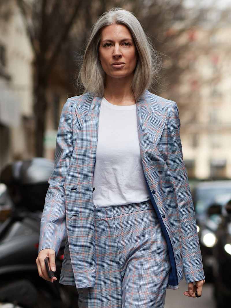 Sarah Harris, Modejournalistin Vogue UK, trägt ihr langes graues Haar offen und dazu einen stilvoll geschnittenen Zweiteiler mit Karomuster