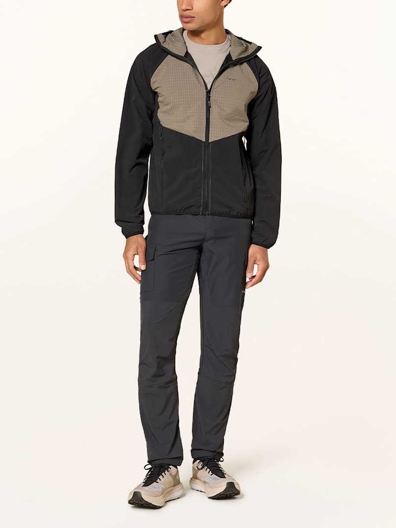 Mann trägt eine schwarze Softshell-Wanderhose
