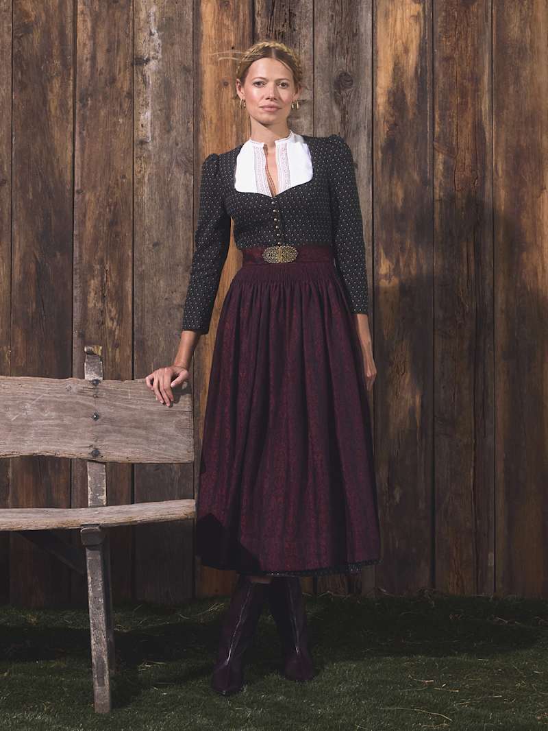 Blonde Frau trägt Dirndl in Bordeaux und Braun