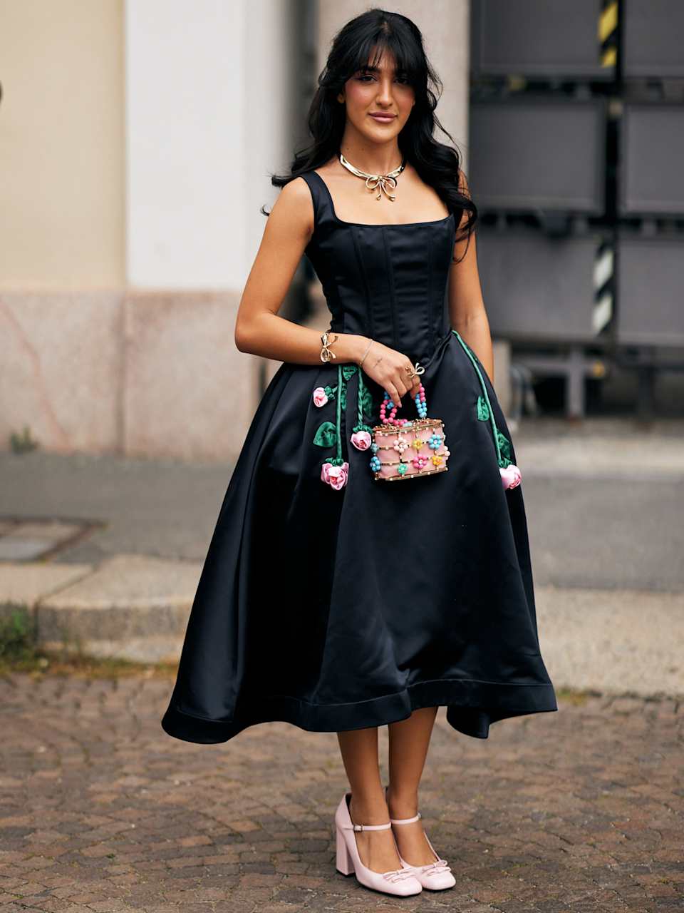 Frau trägt ein schwarzes Midi-Kleid mit Blumen-Stickerei