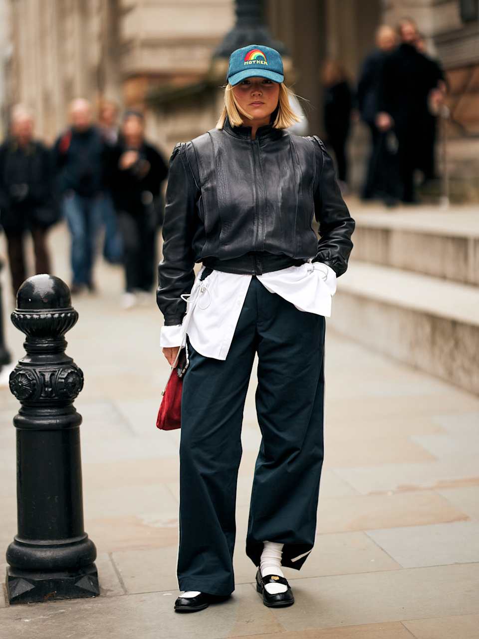 Frau trägt Lederjacke und eine Hose zu Loafer