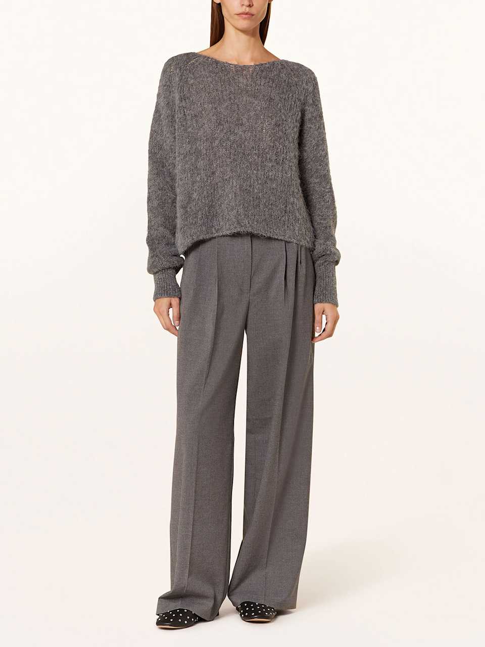 Frau trägt grauen Strickpullover 