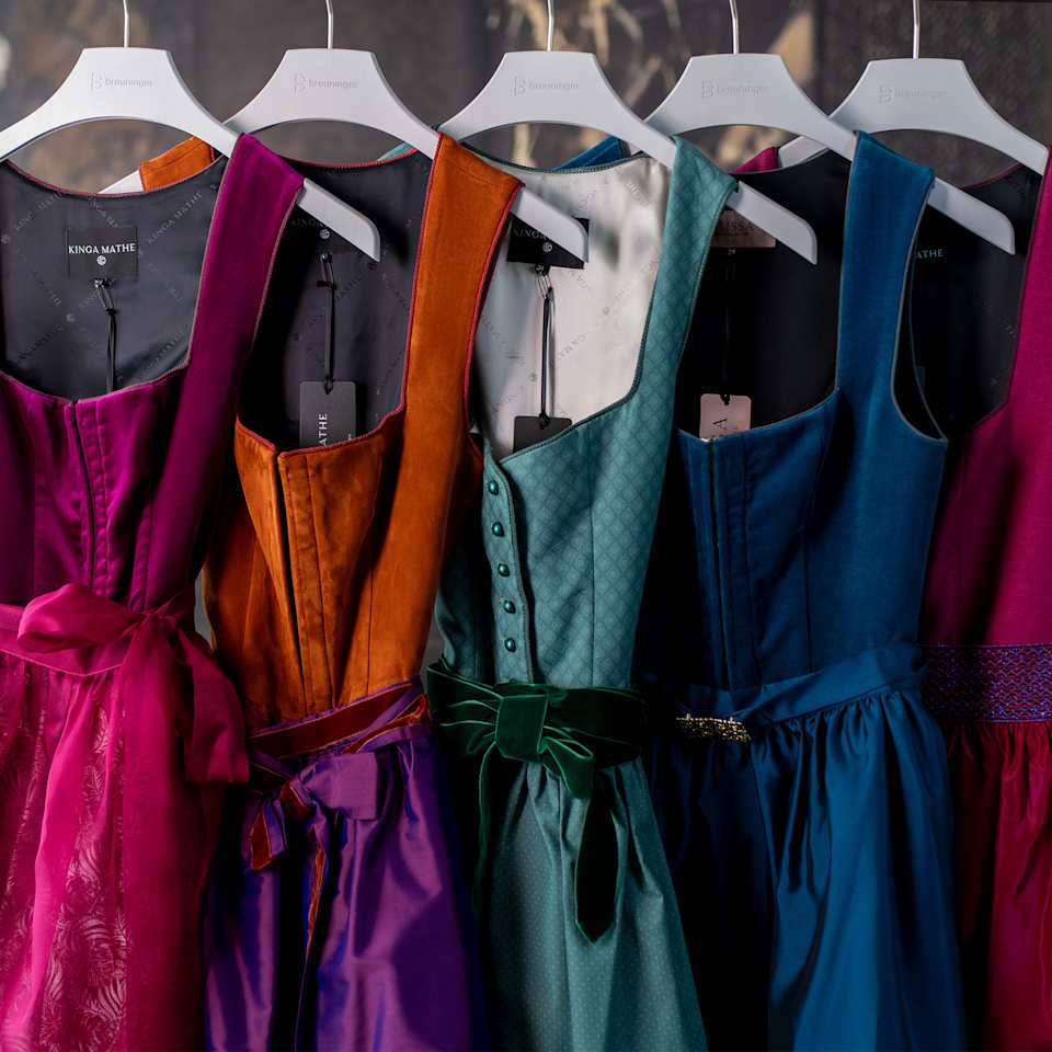 Mehrere Dirndlkleider in verschiedenen Farben auf Kleiderbügeln