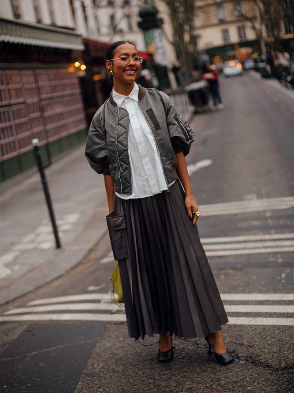 Frau trägt High Heels zu einem Plisseerock Outfit