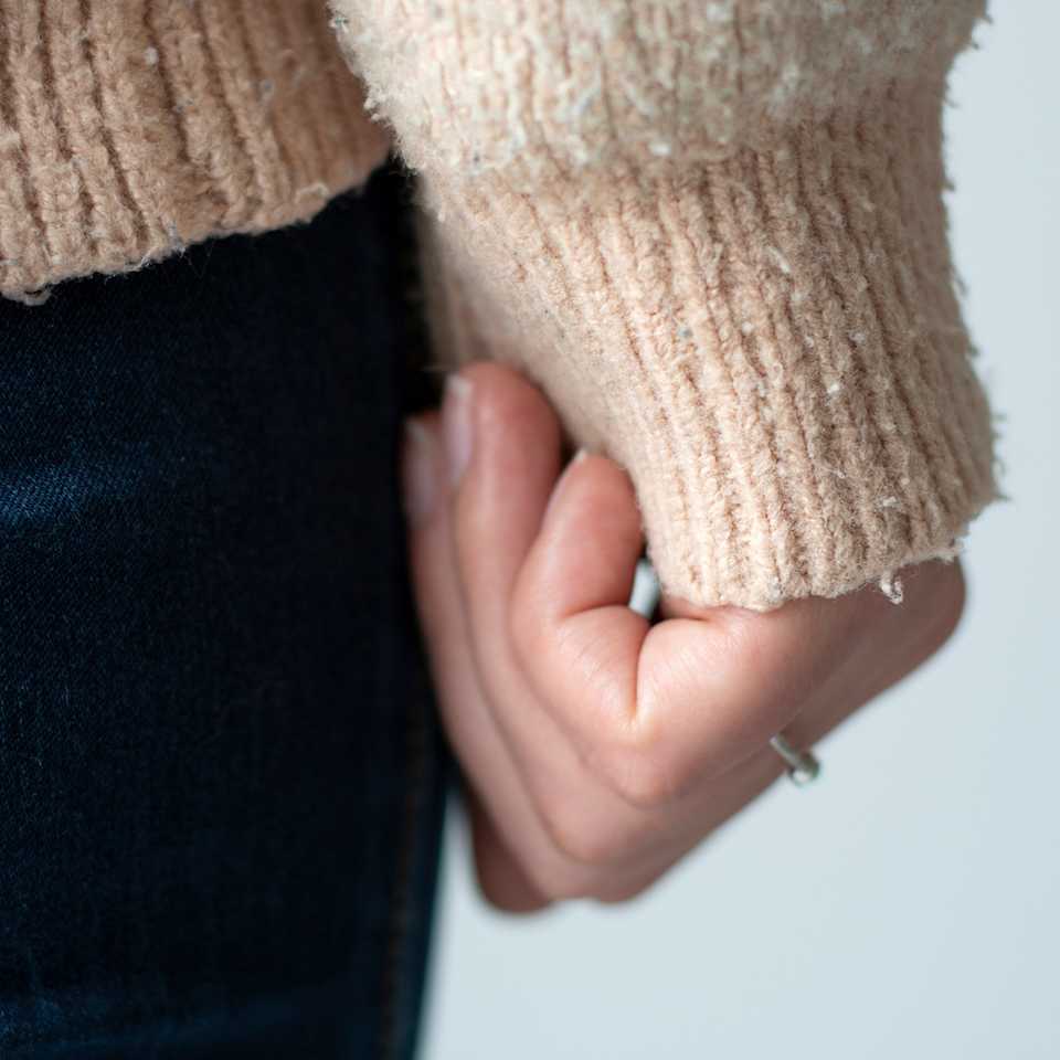 Frau mit kleinen Faserknötchen am Pullover