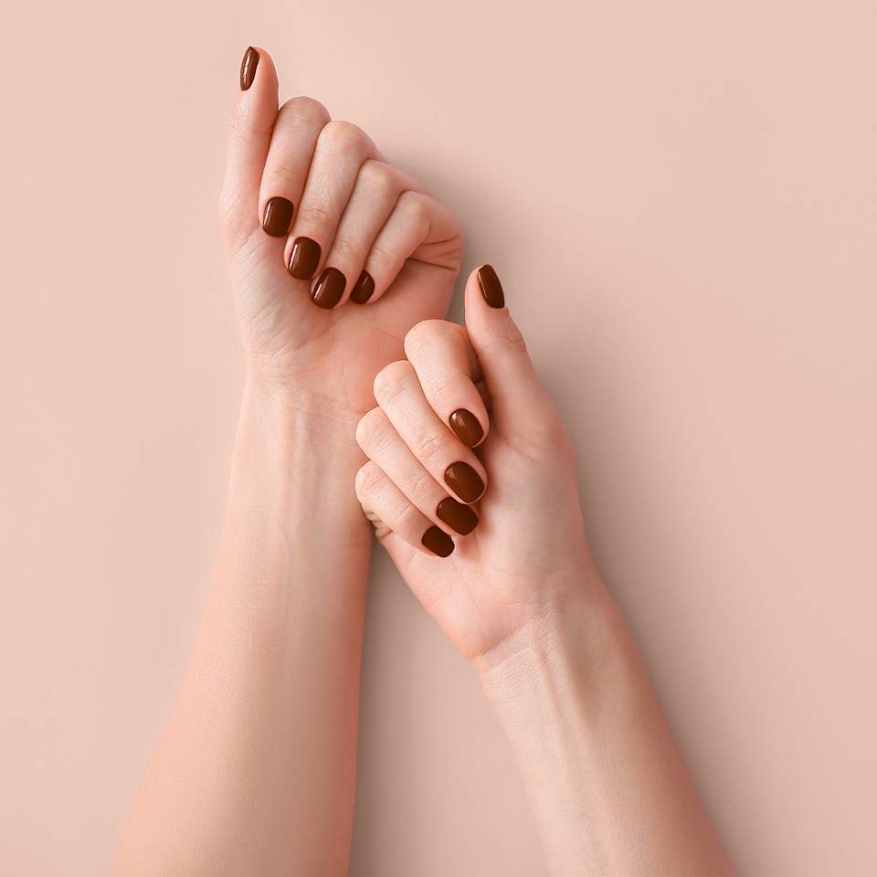 Zwei Hände mit dunkelrotem Nagellack
