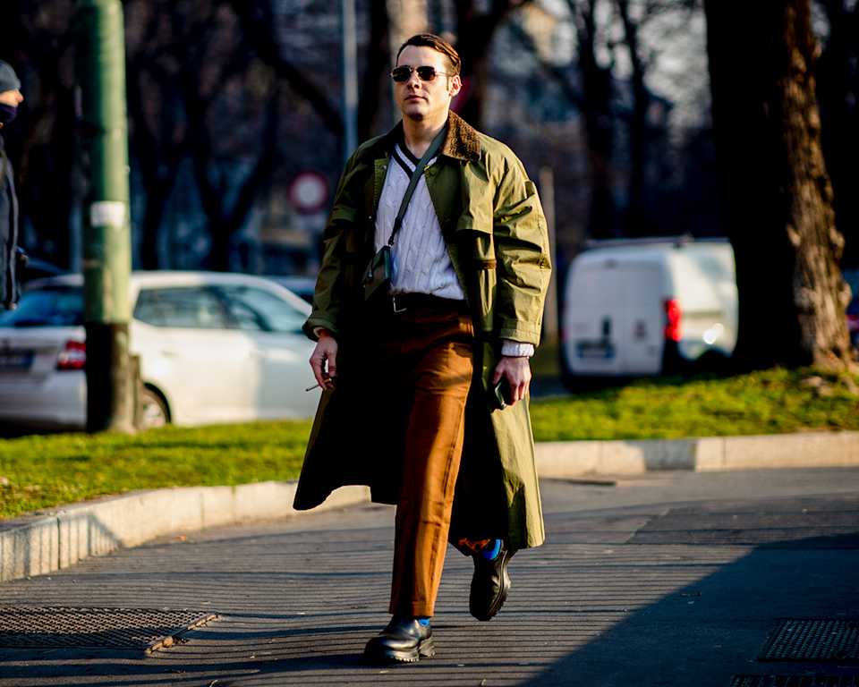 Mann trägt Chino und Trenchcoat 