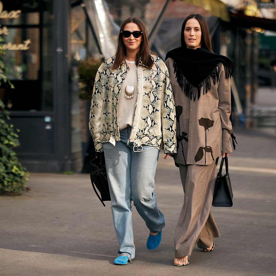 Zwei Frauen stehen nebeneinander und tragen die neusten Herbst-Outfits, eine Animal Print Jacke und einen braunen Hosenanzug