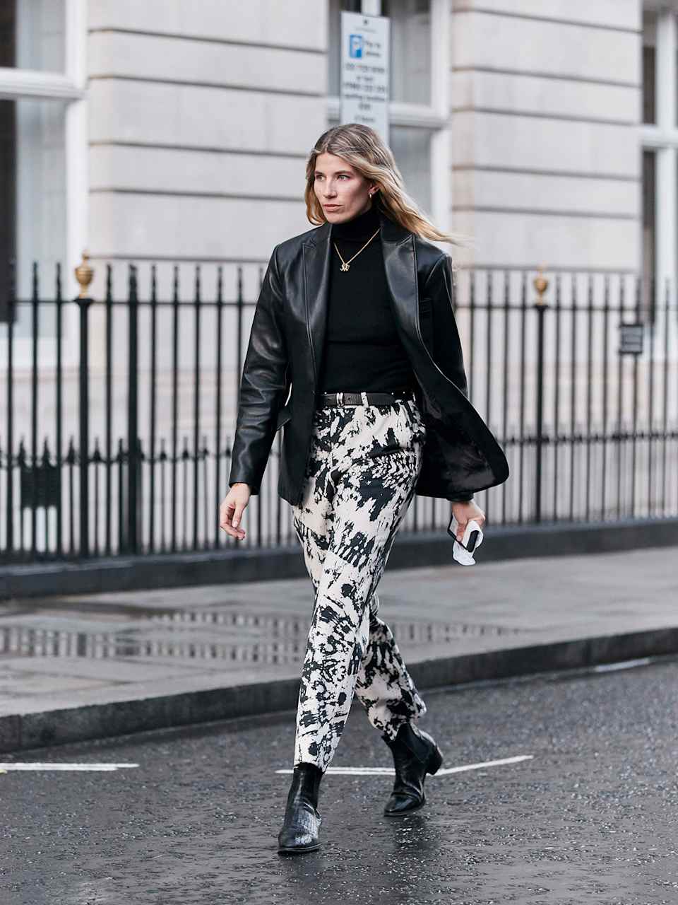 Frau trägt Blazer in der Farbe Schwarz zur Batikmuster-Hose