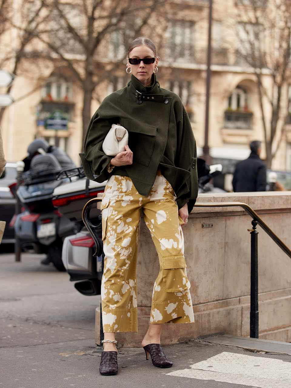Frau trägt Caban Jacke zu einer beigen Hosen mit Batikmuster und Pumps