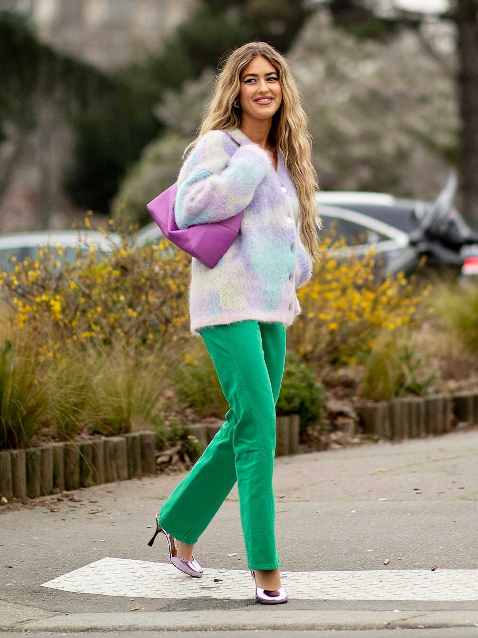 Frau trägt Strickjacke mit Tie-Dye-Muster und eine grüne Jeans