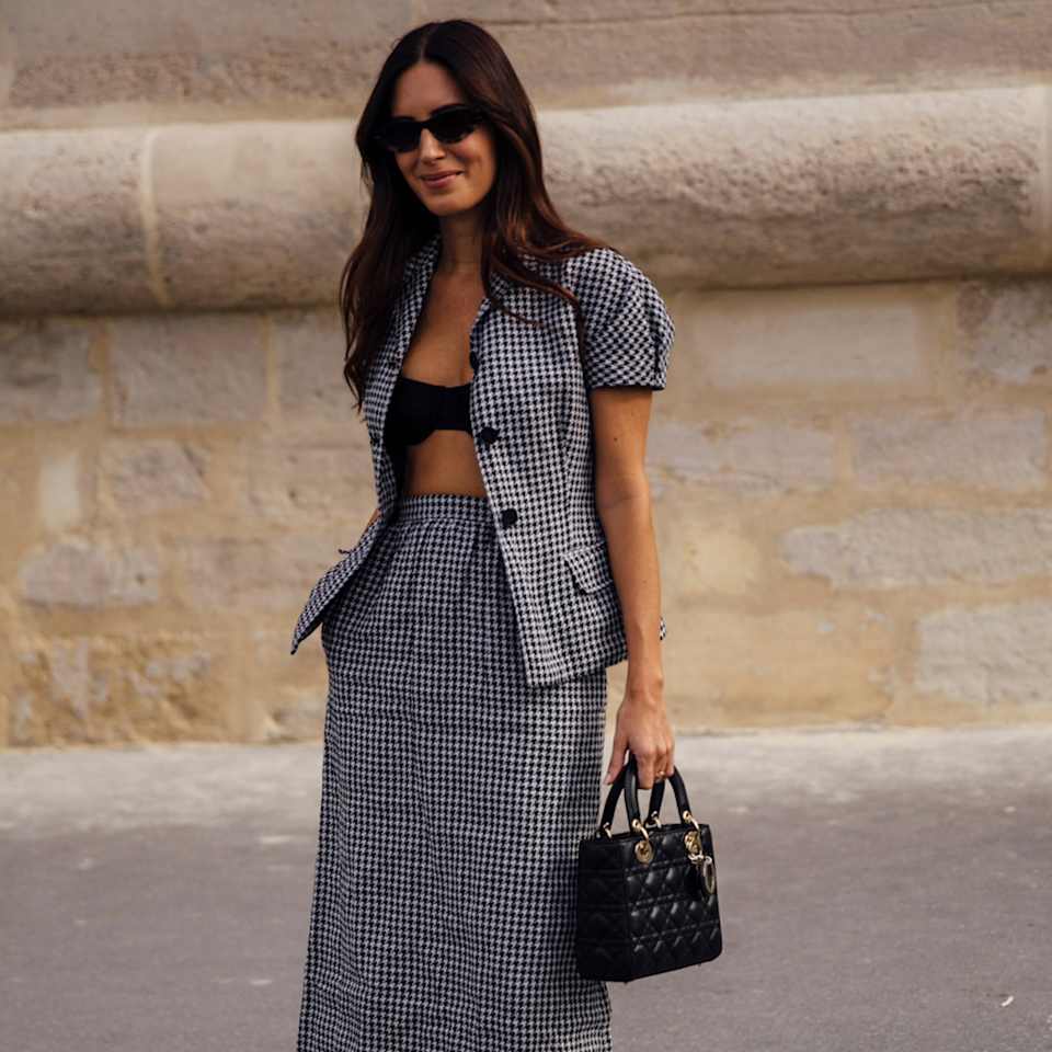 Frau trägt ein Set aus Rock und Bluse in schwarz-weißem Vichy-Karomuster