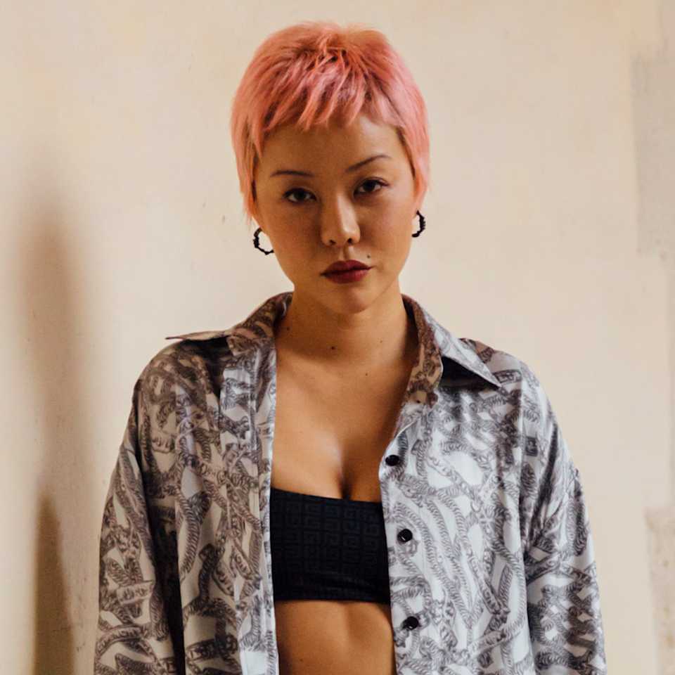 Frau trägt einen pinken Pixie Cut mit Micro Bangs