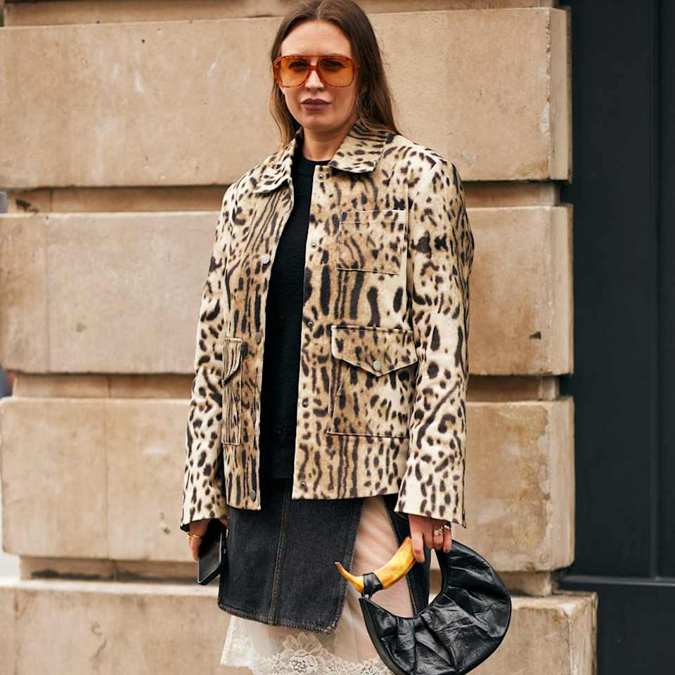 Frau trägt Leopardenmuster-Jacke und Overknees mit Snake Print