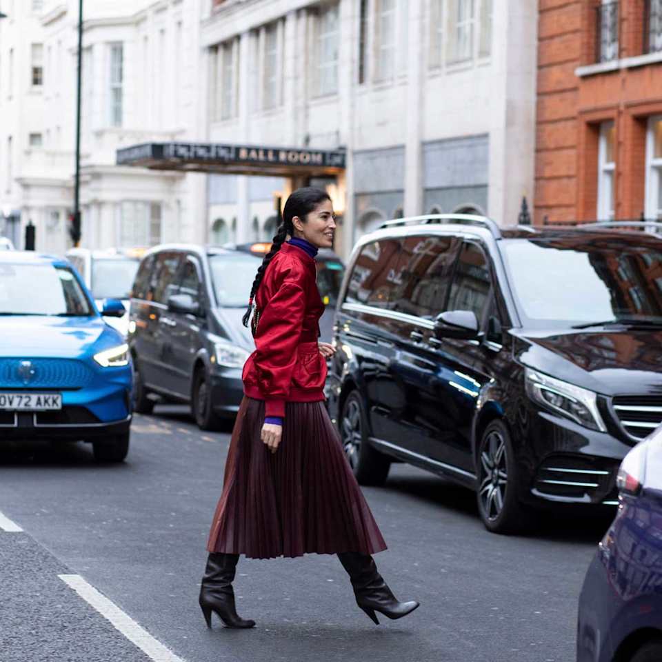 Frau trägt einen roten Plisseerock aus Tüll zu einer roten Bomber 
