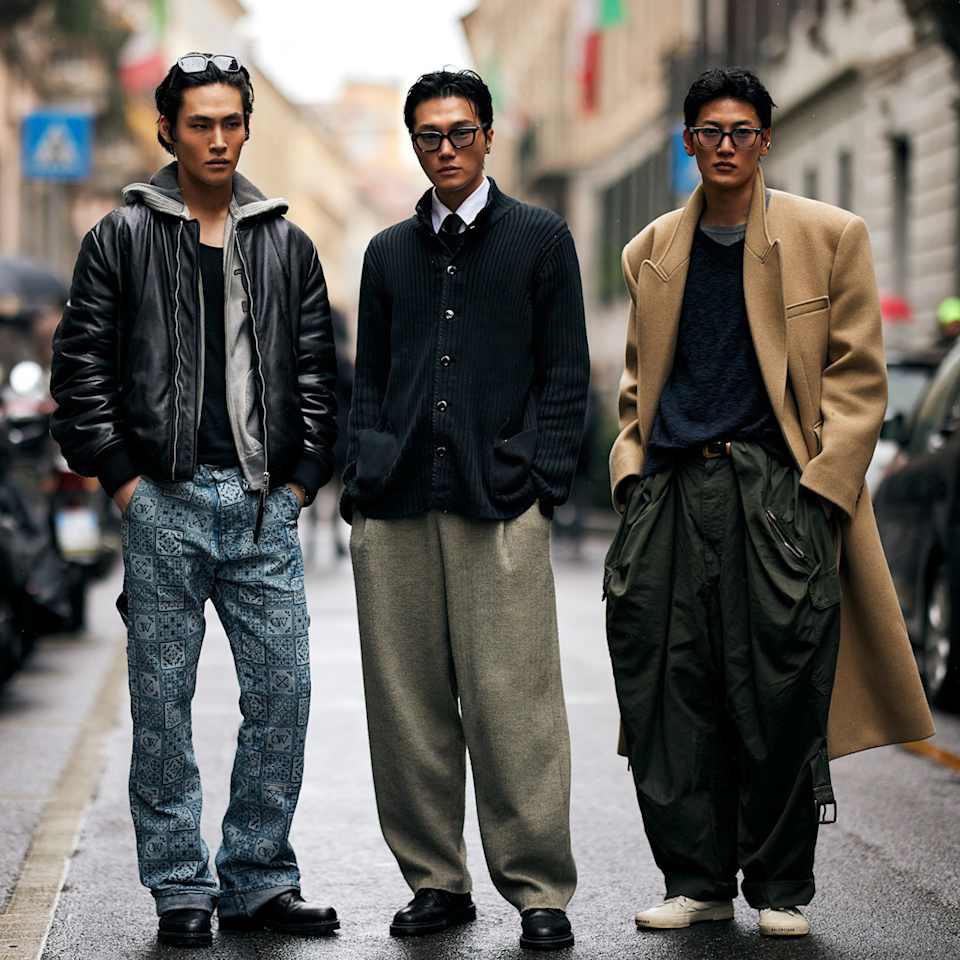 Drei Männer tragen moderne Lederjacken und einen beigen klassischen Wollmantel , kombiniert mit saisonaler Mode für den Herbst/Winter